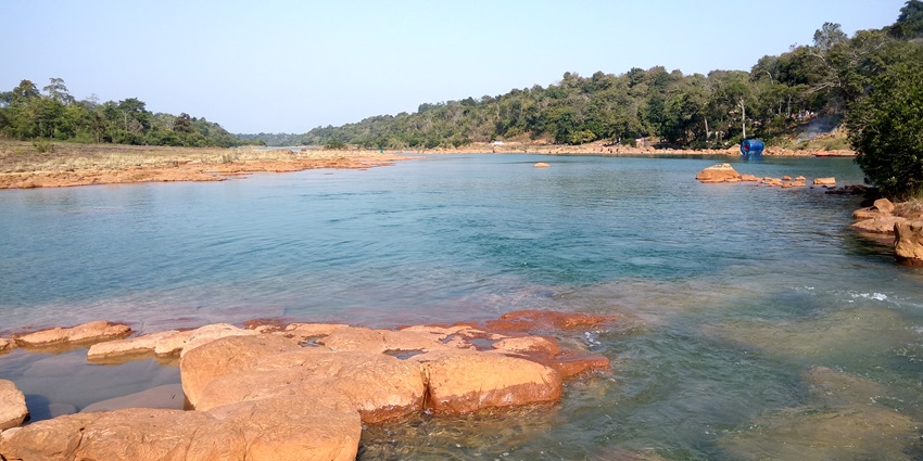 A picture of a waterfall located in Karbi Anglong with scenic views of cliffs and greenery