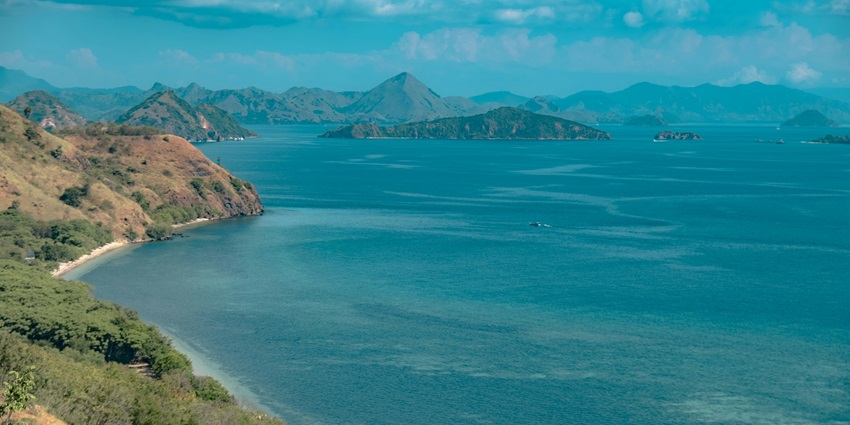 A breathtaking view of an island with azure waters and rocky cliffs during the day.