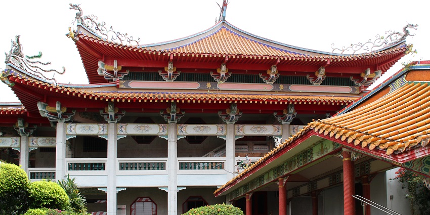 A picture of a monastery in Singapore taken from its garden with green plants