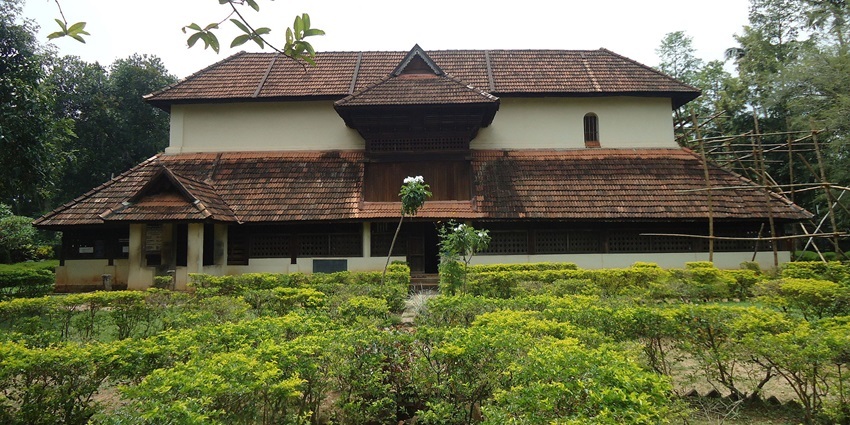 A picture of a beautiful palace with a lush green garden area in front of it