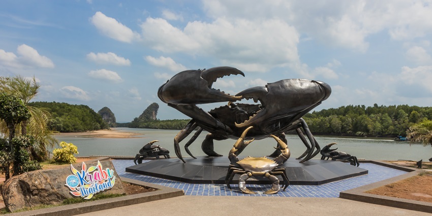 A big sculpture of a crab in the Krabi Town with a water body and an island in the background