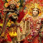 A picture of a temple's interior with the idols of Lord Krishna and Goddess Radha donned in luxury clothes