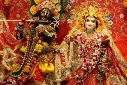 A picture of a temple's interior with the idols of Lord Krishna and Goddess Radha donned in luxury clothes