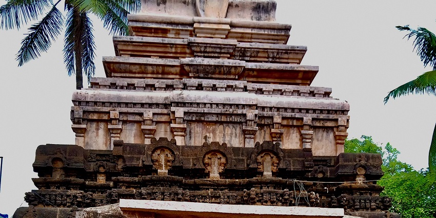 A picture of a place of praying, with lush green trees and clear sky in the background.