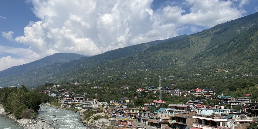 A stunning aerial view of a town with colourful houses and mountains in the background.