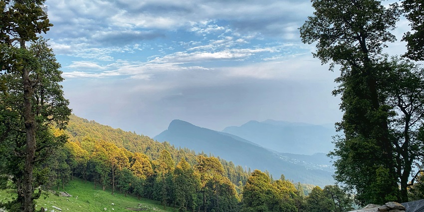Lush green hills of Kullu Valley under a vibrant blue sky - Hill Stations Near Palampur.