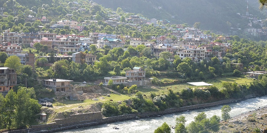 The city of kullu on the bank of a river near the khokhan wildlife sanctuary