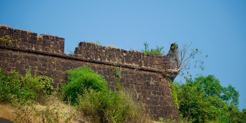 A glimpse of the rustic Kutlehar Fort surrounded by lush greenery in Himachal Pradesh.