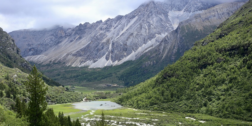 A scenic view of rolling valleys, snow-capped mountains, and azure lakes in Lachen.