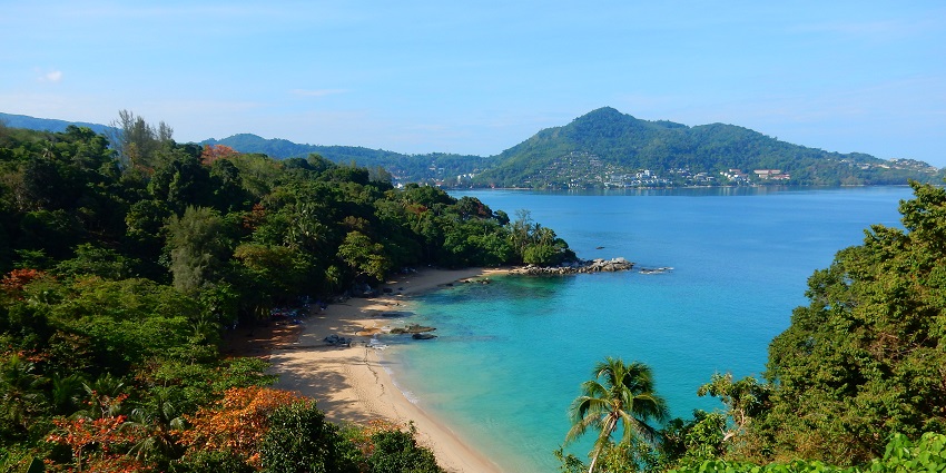 A view of Laem Singh Beach comprising azure waters, golden sands and lush greenery.