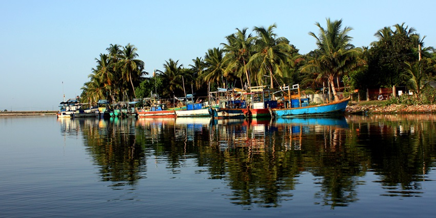 Batticaloa Lagoon with fishing boats moored on the water, surrounded by lush greenery.