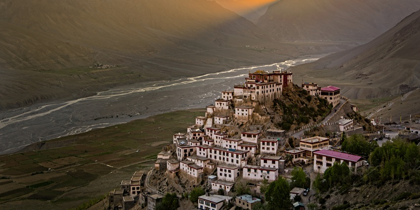 A Buddhist monastery on top of a hill during sunset
