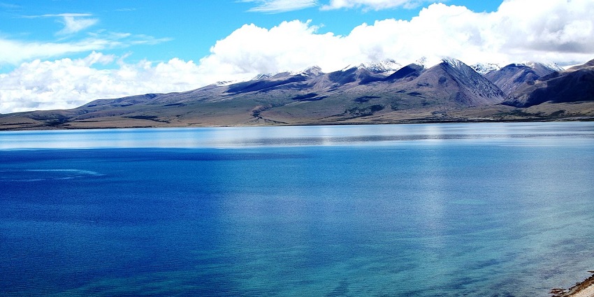 A mesmerising view of the turquoise waters of the famous Manasarovar Lake with cloudy sky.