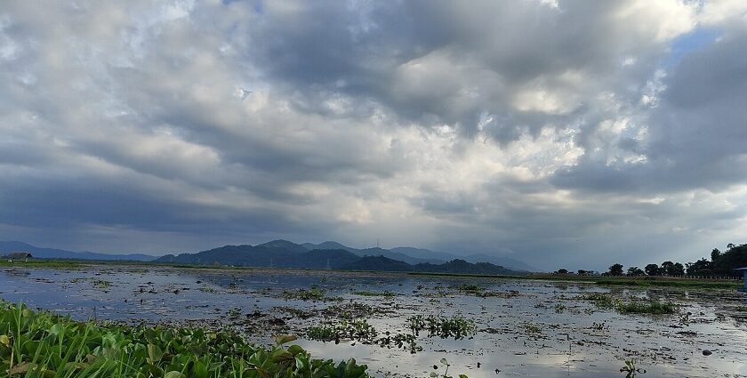 Lakeside view with waters reflecting the trees and mountains - Places To Visit In Goalpara.