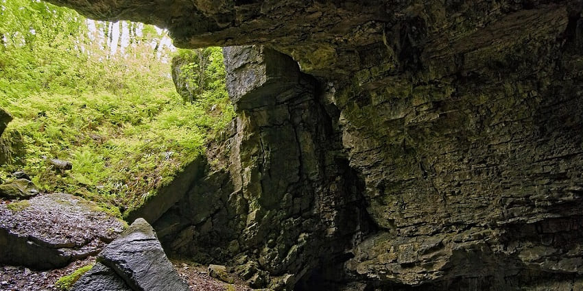 Image of a cave surrounded by lush greenery, huge rocks cave - famous places in Jhibi