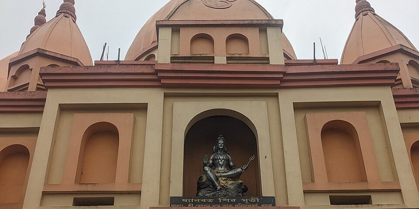 A picture of the entrance of a traditional temple in Guwahati with an idol of Lord Shiva over it
