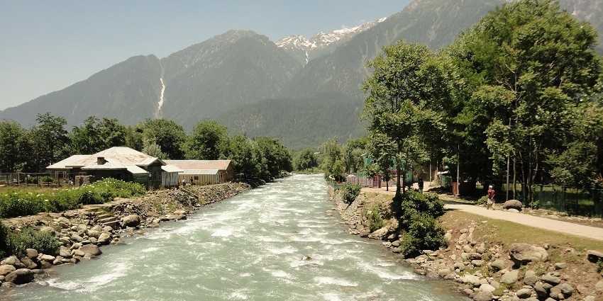 A view of the Lidder River that flows through the valley in Pahalgam, surrounded by lush mountains