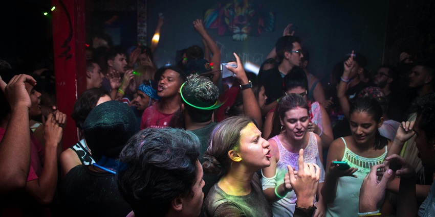 Image of people dancing in a club around the vibrant lights and crowd at Phuket city life