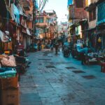 A view of people walking on a street with shops on both sides during the daytime.