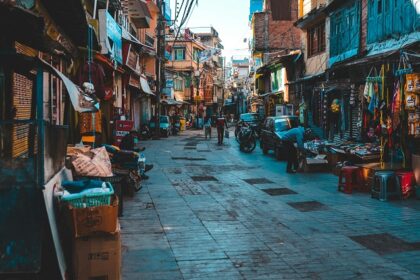 A view of people walking on a street with shops on both sides during the daytime.