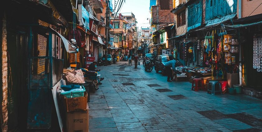 A view of people walking on a street with shops on both sides during the daytime.