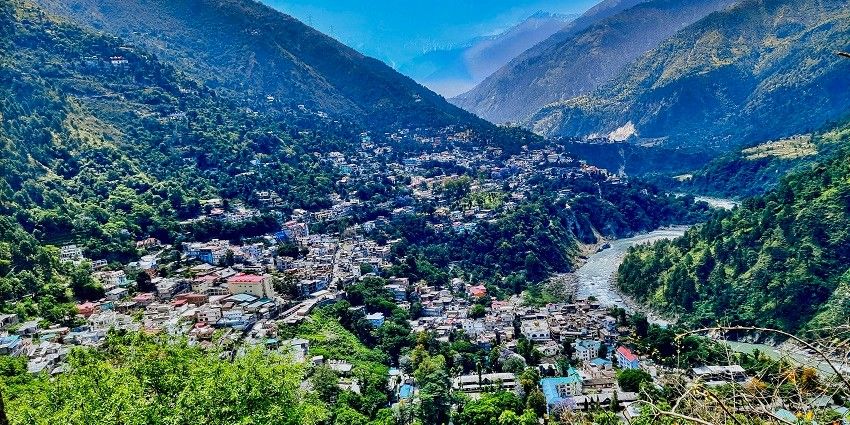 An aerial view of the Chamba town with mountains and a river in the background