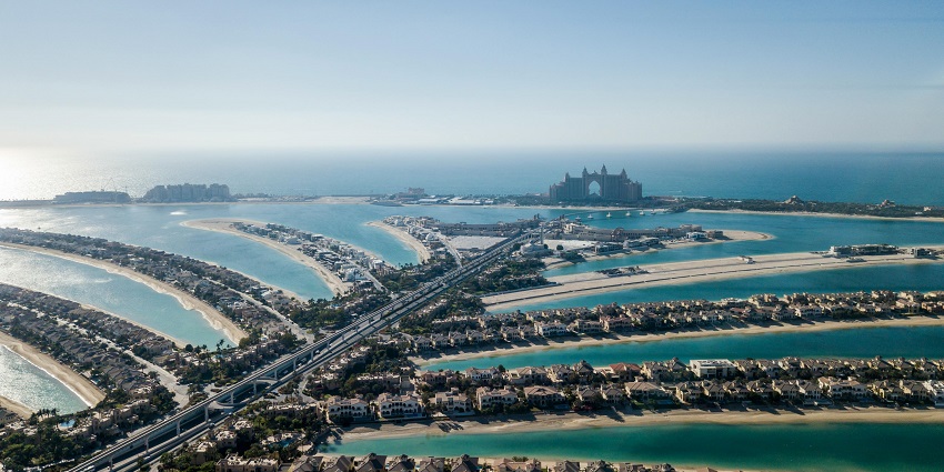 A stunning aerial view of Palm Jumeirah surrounded by turquoise waters during the day.