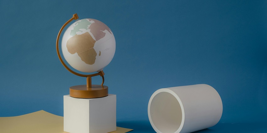 A fascinating view of a white and golden globe on a white box against a blue backdrop.