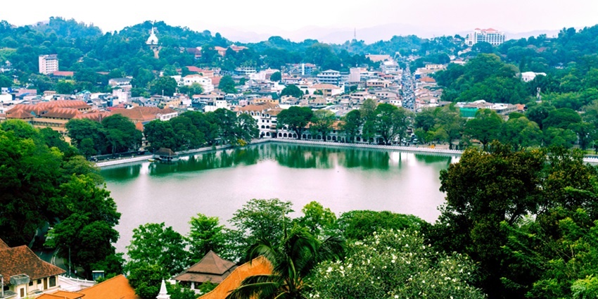 A serene view of the lush vegetation and small houses of Kandy city in Sri Lanka.