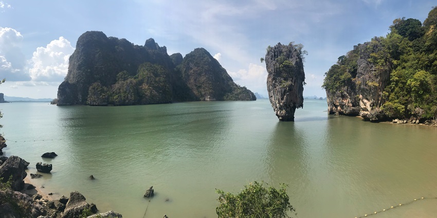 A serene view of tranquil waters of James Bond Island dotted with green-capped peaks.