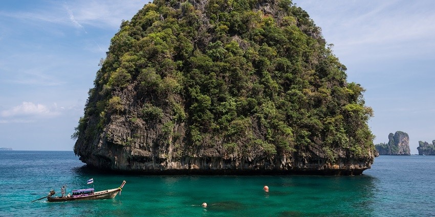 A picture of a tall mountain-like island surrounded by water from all the sides