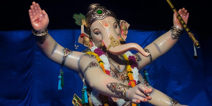 Colourful statue of Lord Ganesha, adorned with vibrant ornaments and intricate detailing.