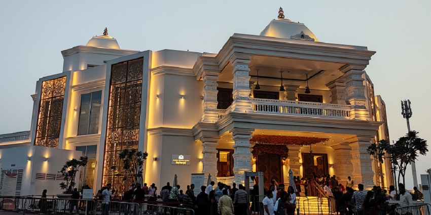 A frontal view of a Hindu temple in Dubai with devotees lined up at its entrance