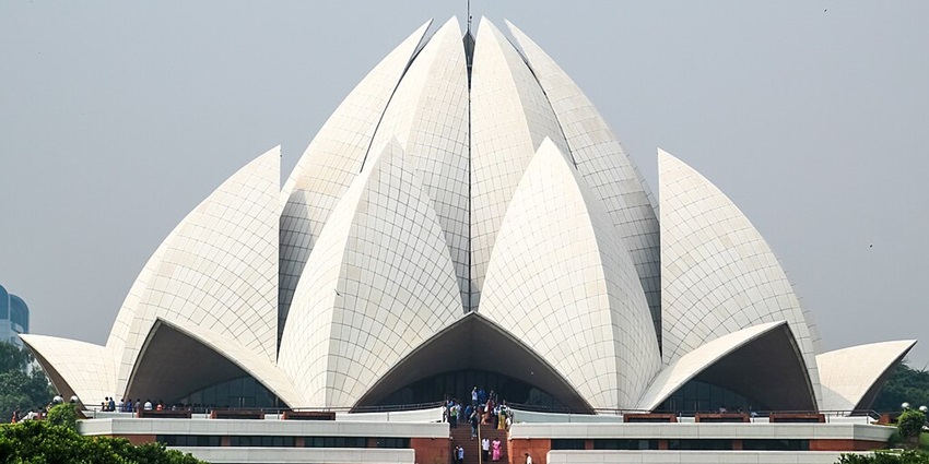A frontal view of the Lotus Temple in Delhi with lines of visitors visible in the front entrance
