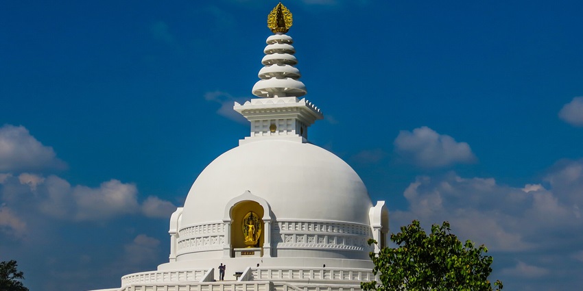 A Buddha temple in Delhi made in the shape of a tall white pagoda with a golden sculpture of Buddha