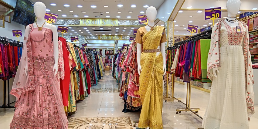 A picture of a designer store with numerous mannequins placed with wedding outfits in a well-lit area