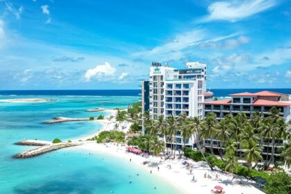 A breathtaking view of a beautiful island in the Maldives with turquoise ocean and hotels.