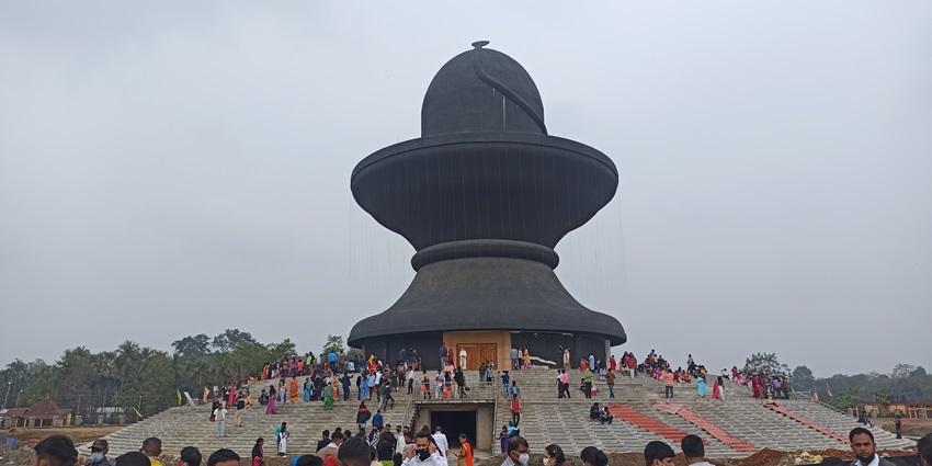 A picture of a huge Shiva Lingam sculpture at a temple in Assam, with devotees all around