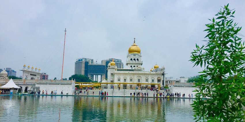 Beautiful image of sarovar and the gurudwarka in the background amdist the greenery