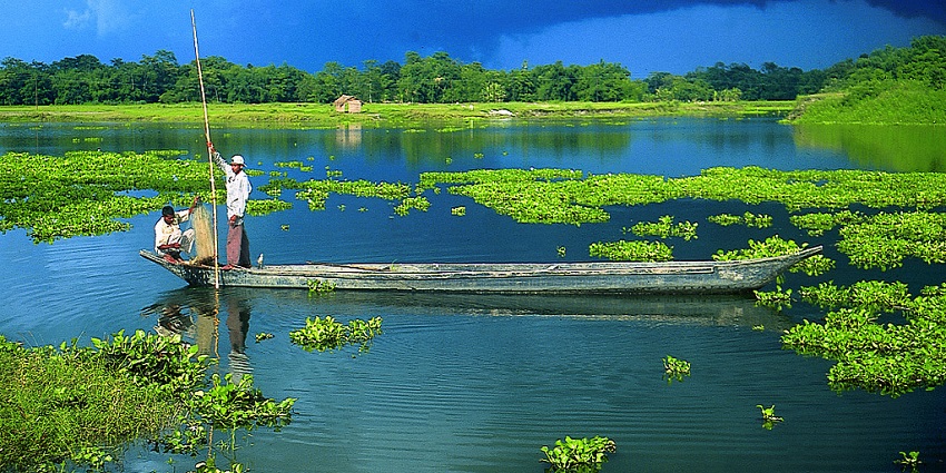 Scenic view of two men riding a boat in Majuli Island - things to do in Assam