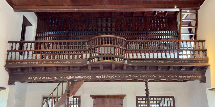 A picture of the interiors of a bungalow with a wooden staircase and balcony