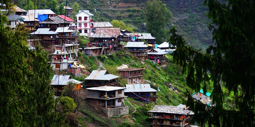 Scenic view of Malana village in the Himalayas, showcasing traditional architecture and lush greenery.