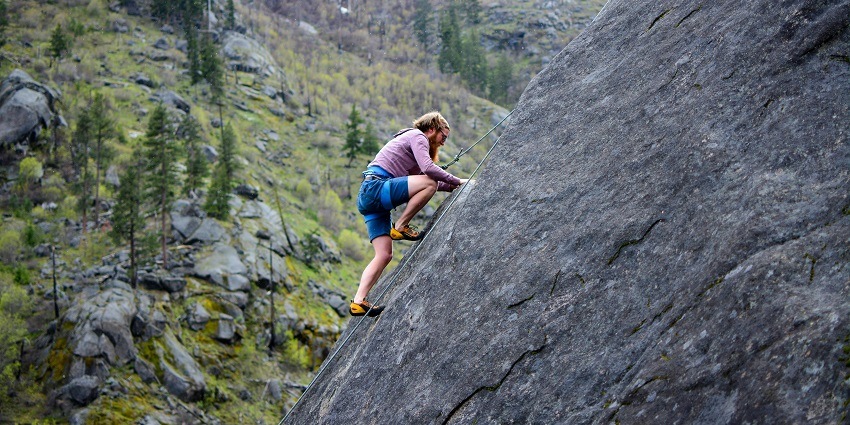 Man skillfully climbs a rocky mountain, showcasing determination and adventure.