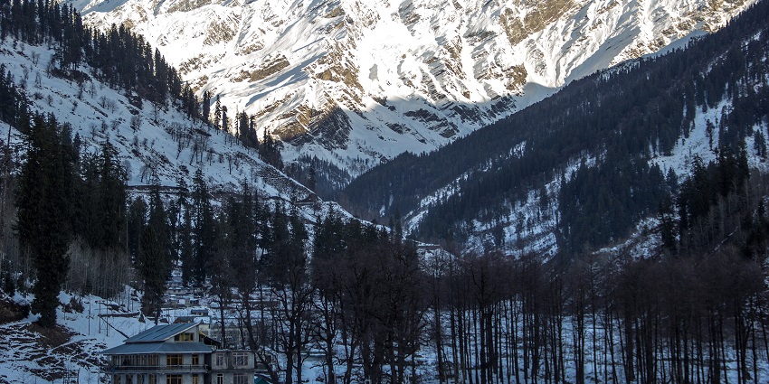 Mesmerising view of snow covered landscapes of manali with pine tress and cottages