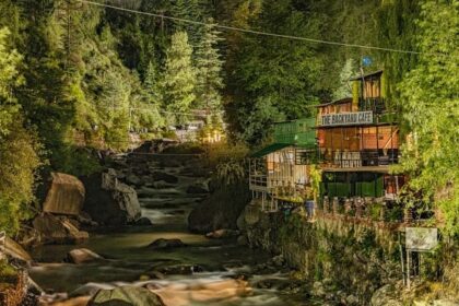 A breathtaking view of a sparkling river flowing through a lush green valley in Manali.