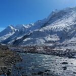 A picture of a hill station covered in snow during winter season under a bright sun