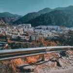 A breathtaking view of Mandi with colourful houses and mountains in the background.