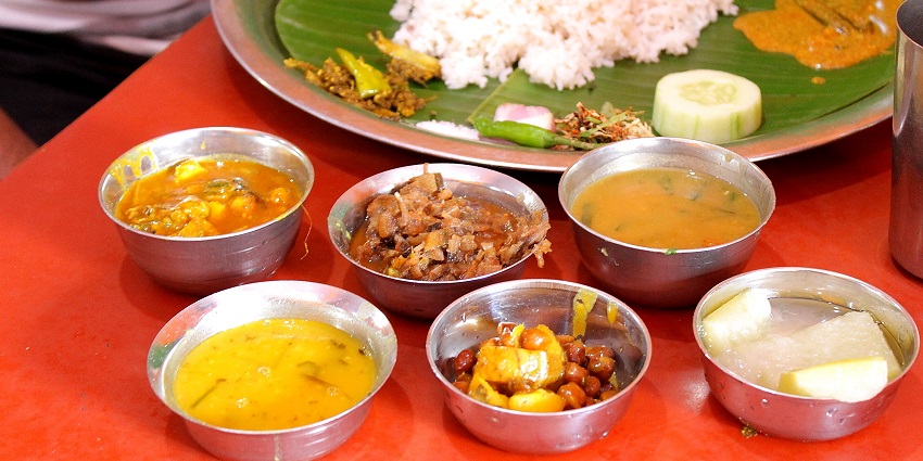 Traditional Manipuri Thali with an array of vibrant dishes served on a banana leaf.