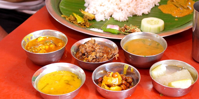 Manipuri food thali with a variety of traditional dishes, arranged on a banana leaf.