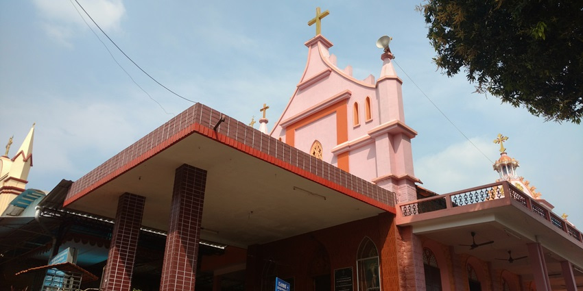 A picture of a Church near the Perunthenaruvi Waterfalls with traditional architecture and a cross on the rooftop